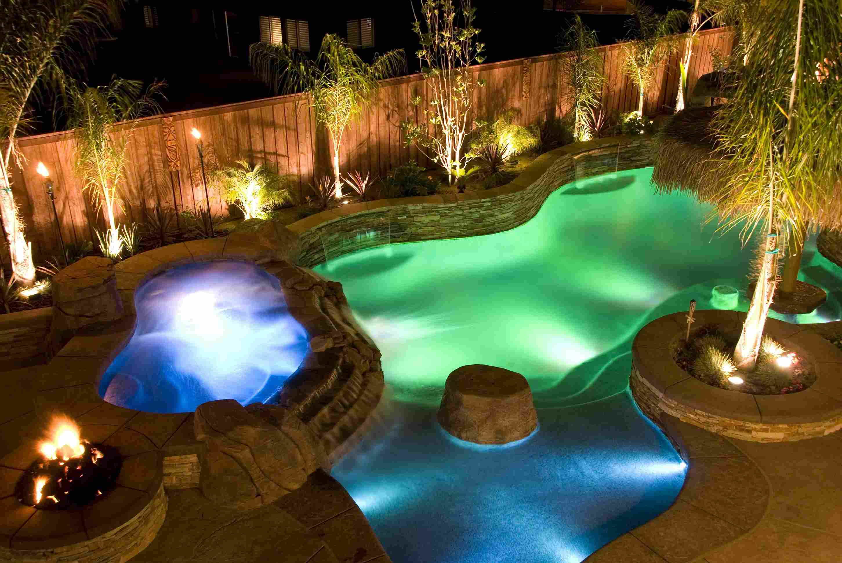 Backyard pool at night with color-changing LED lighting